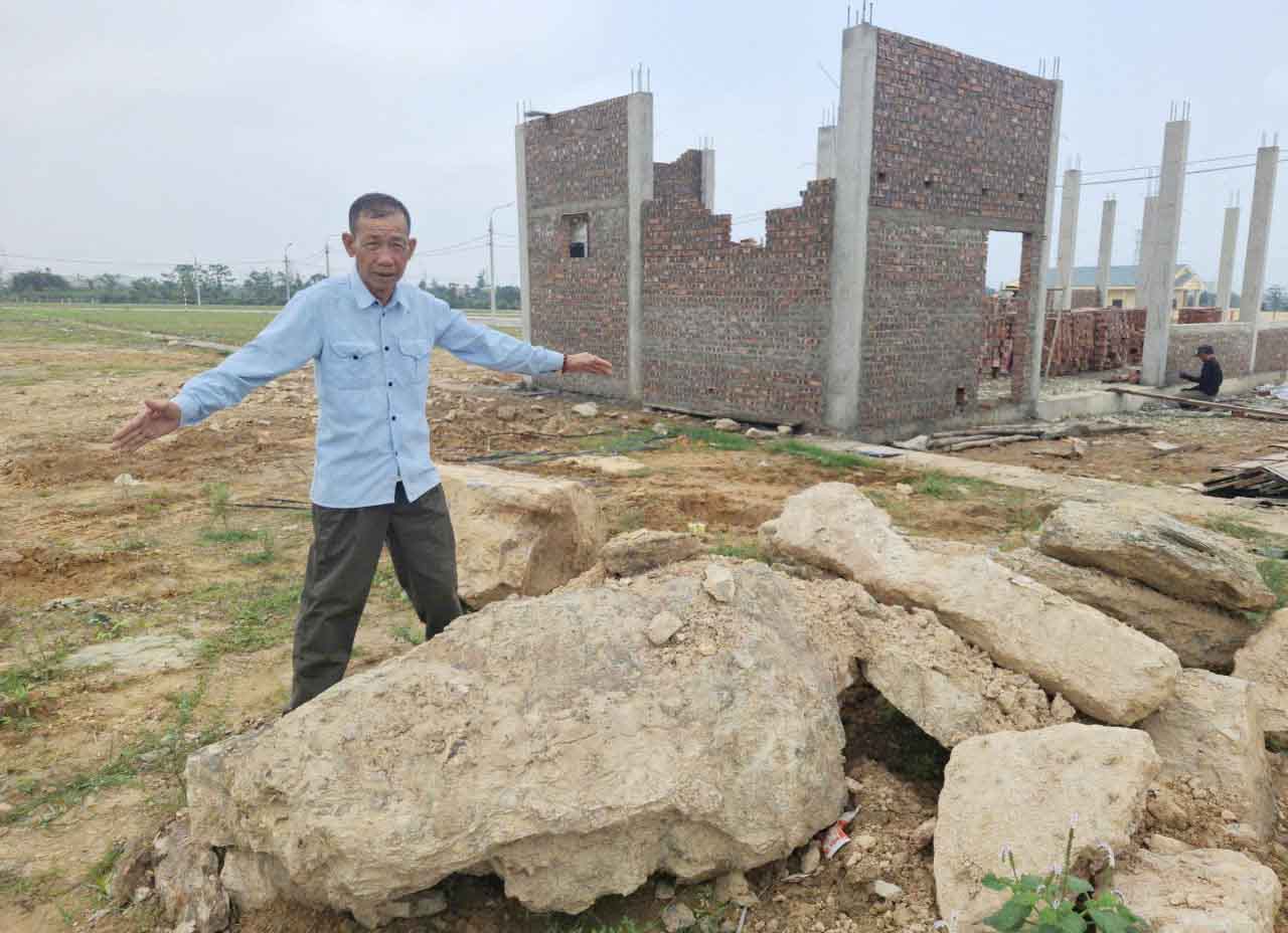 Ông Định than phiền khi đào móng làm nhà tại khu tái định cư đã bắt gặp nhiều đá tảng lớn gây khó khăn cho thi công và tốn thêm kinh phí. Ảnh: Trần Tuấn