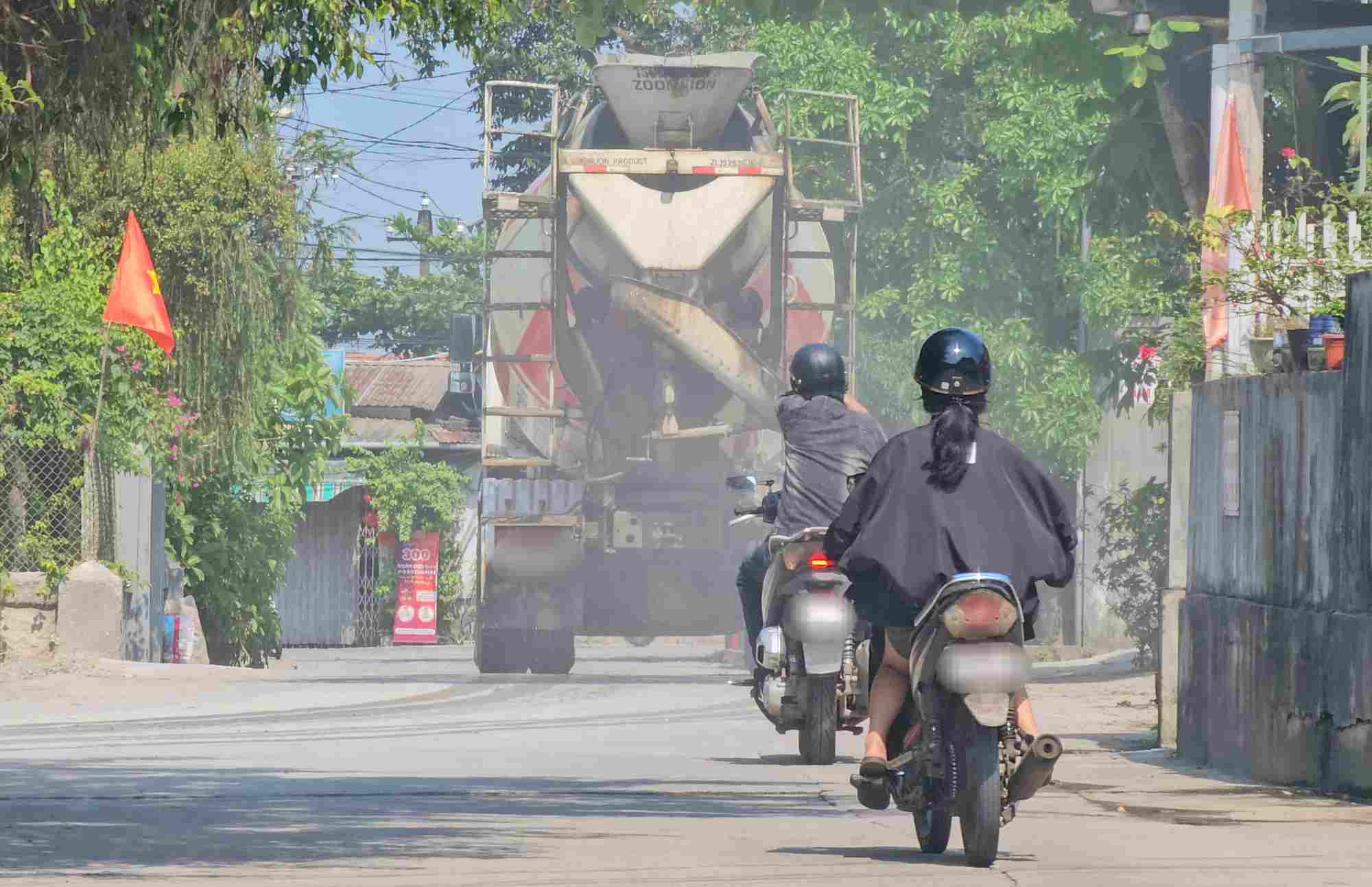 Wherever concrete trucks move, dust rolls up white. Photo: Reporter