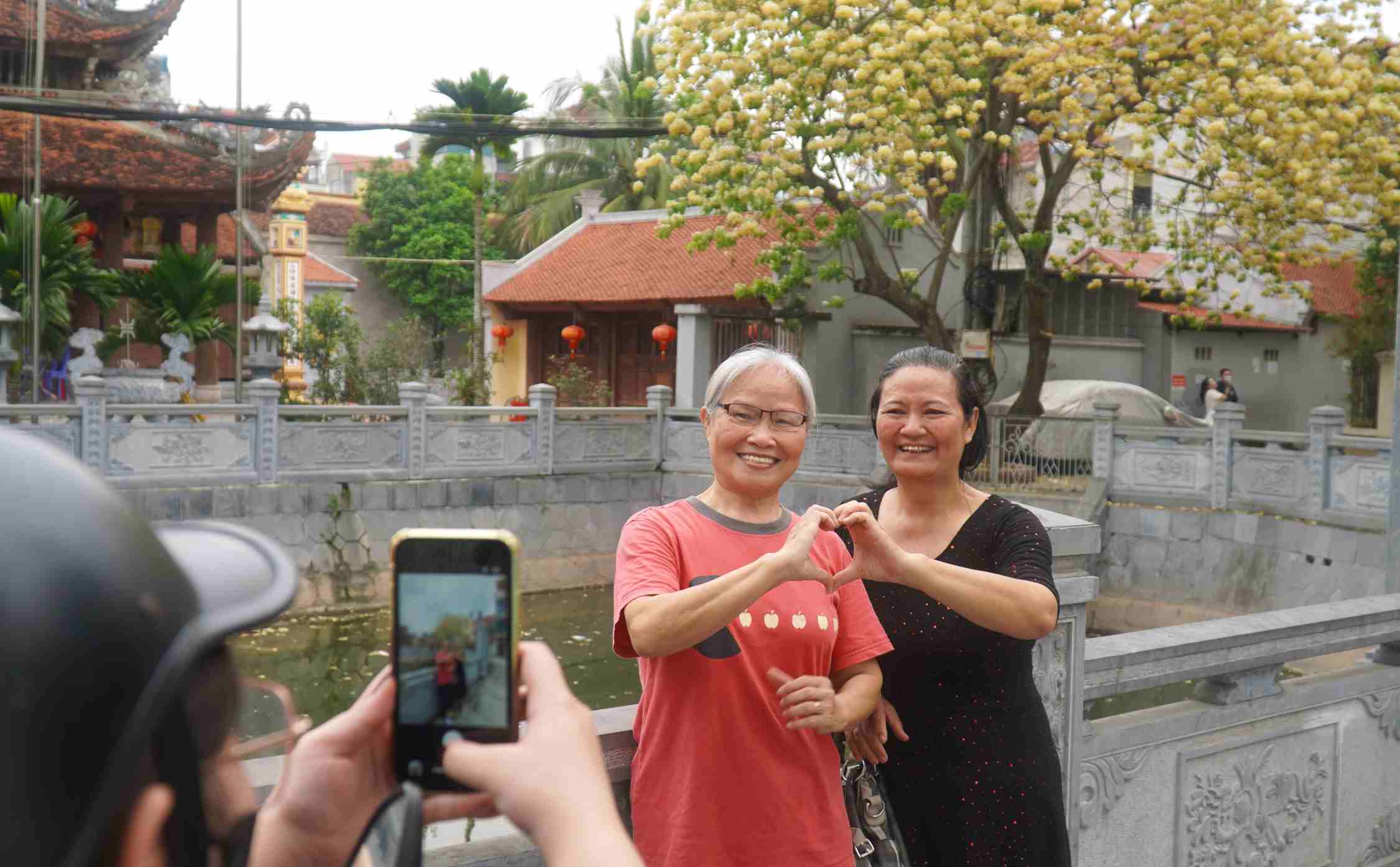 Bà Lan cùng bạn tranh thủ thời điểm hoa đẹp để ghi lại khoảnh khắc. Ảnh: Minh Vũ