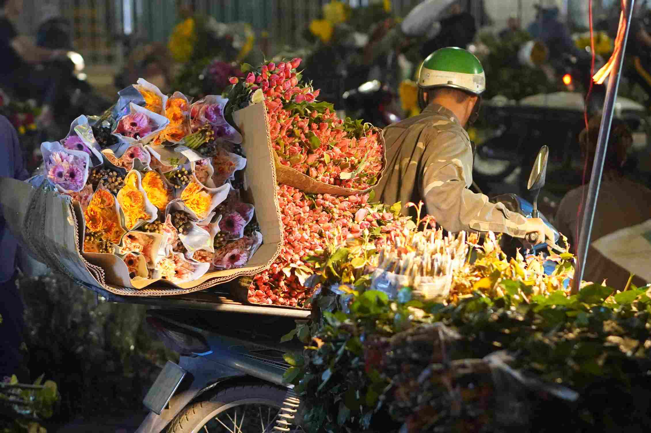 Những bó cúc cùng các loại hoa tươi mới nhập chợ từ nửa đêm, sắc hoa nổi bật giữa ánh đèn. Ảnh: Minh Vũ