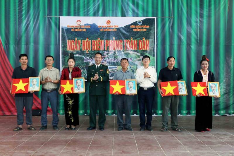 Tặng cờ Tổ quốc và ảnh Bác Hồ cho đại diện các bản thuộc xã Mường Lèo. Ảnh: Hoàng Giáp
