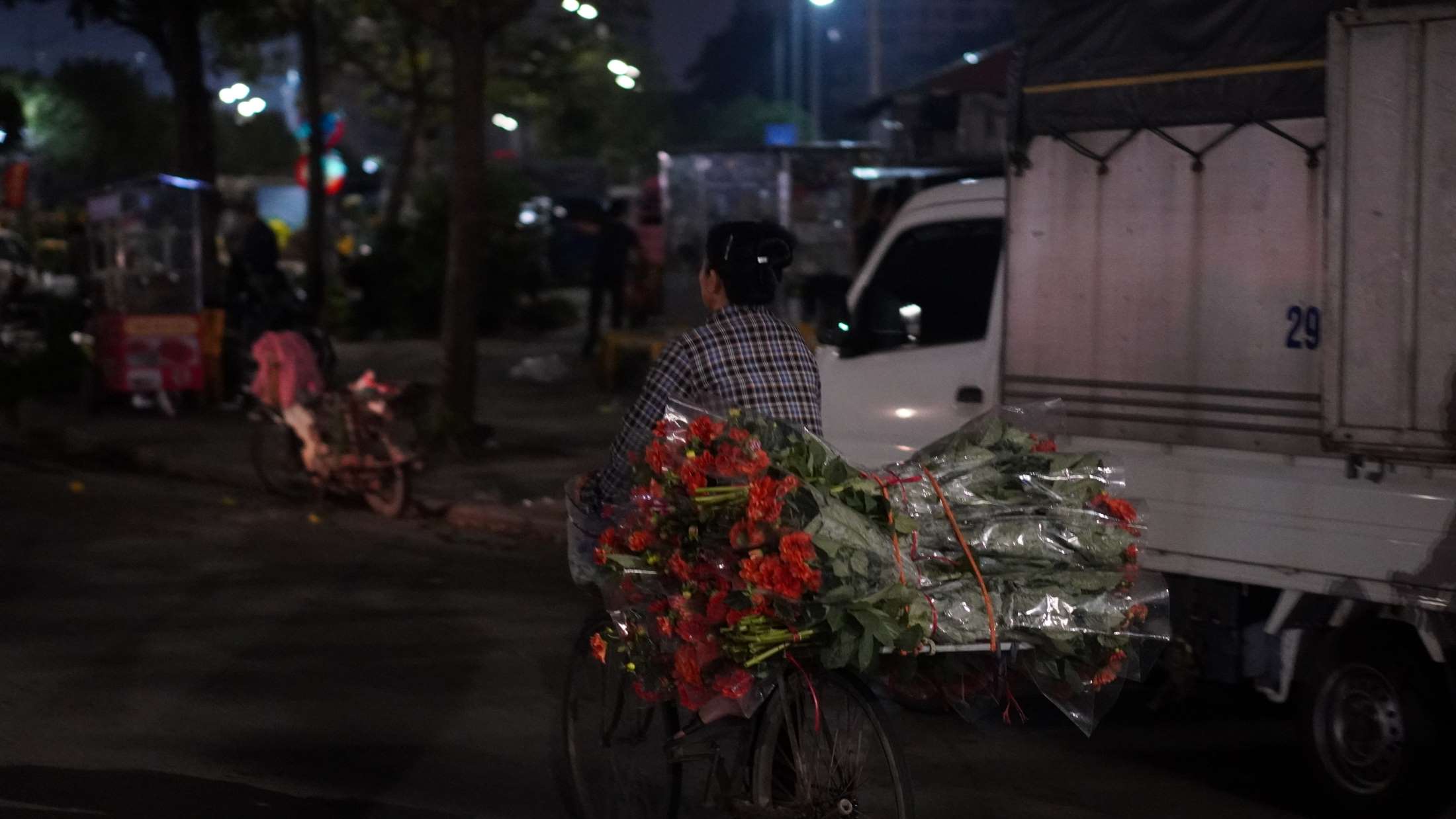Những thương buôn cẩn thận chất từng bó hoa vừa mua lên xe đạp, chuẩn bị tỏa đi khắp các ngõ phố khi trời còn chưa sáng. Ảnh: Minh Vũ