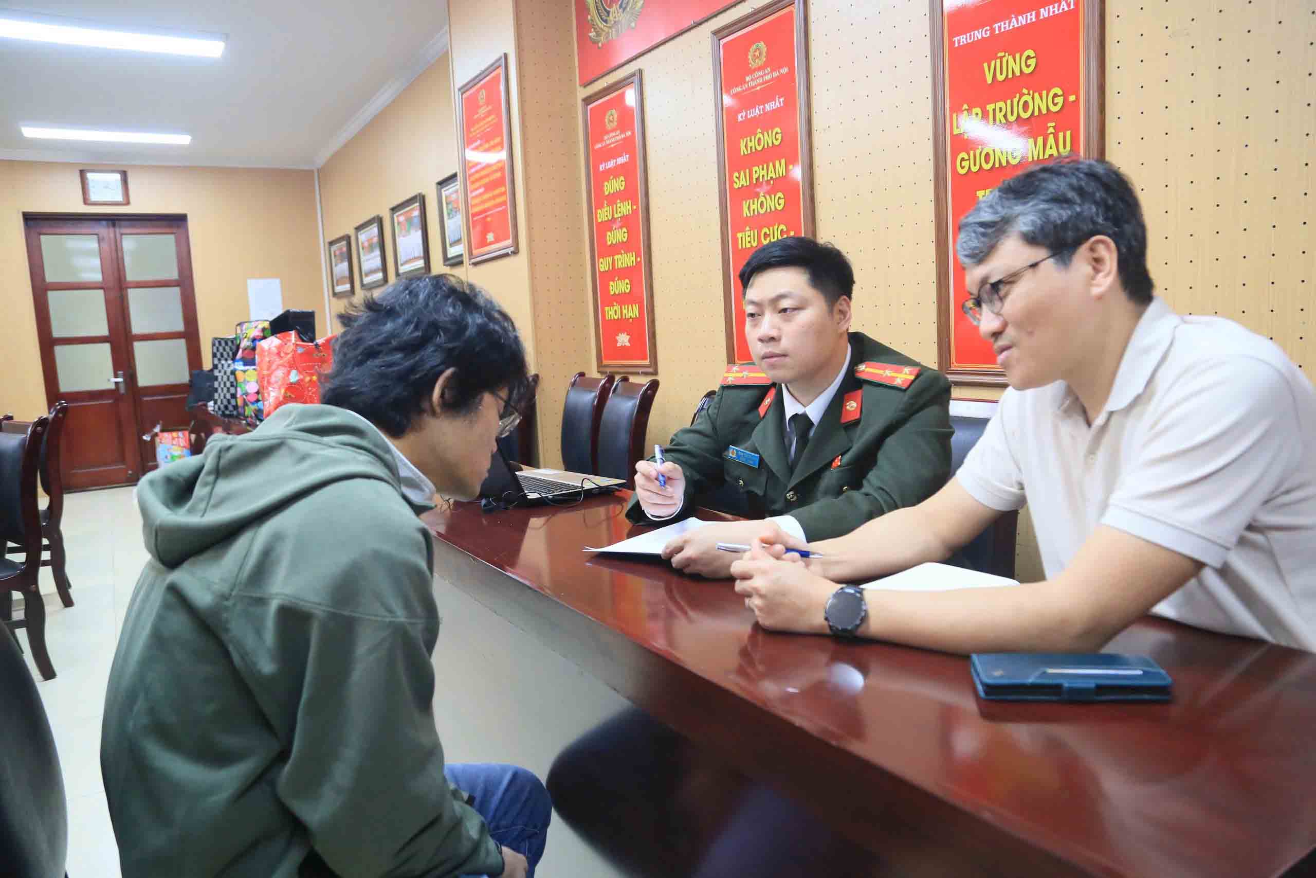 Lực lượng chức năng (phải) lấy lời khai một trong số các đối tượng người nước ngoài có hành vi lừa đảo. Ảnh: Công an Hà Nội 