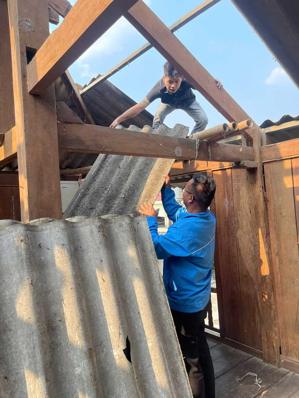 Đoàn viên thanh niên hỗ trợ người dân lợp lại mái nhà bị tốc mái sau bão. Ảnh: Tuổi trẻ Nghĩa Lộ