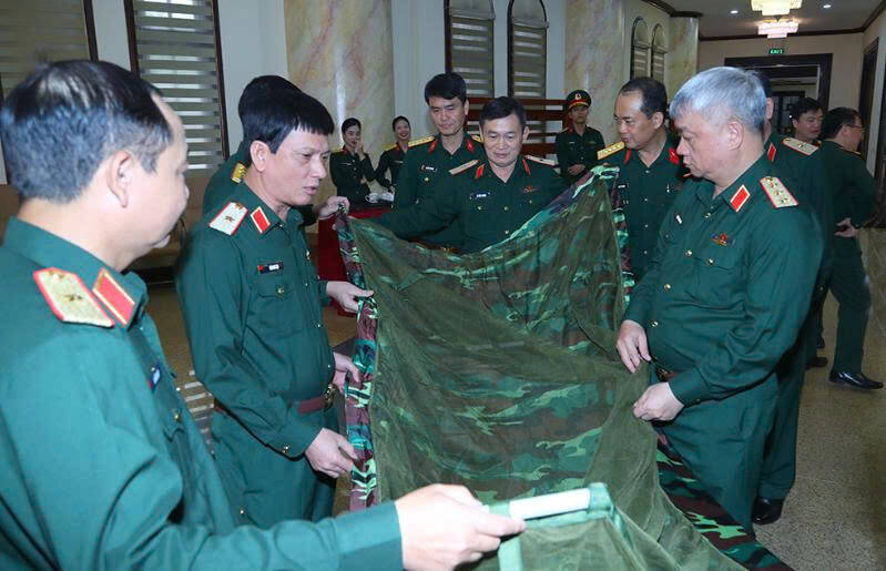 Thượng tướng Nguyễn Quang Ngọc tham quan một số mẫu quân trang được trưng bày tại hội nghị.  