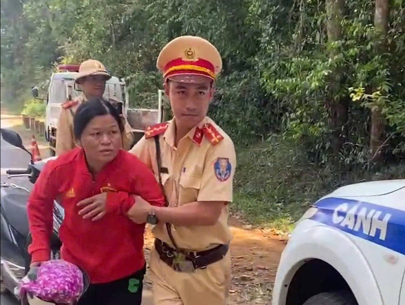 Lam Dong traffic police support a woman with signs of stroke. Photo: Police provided