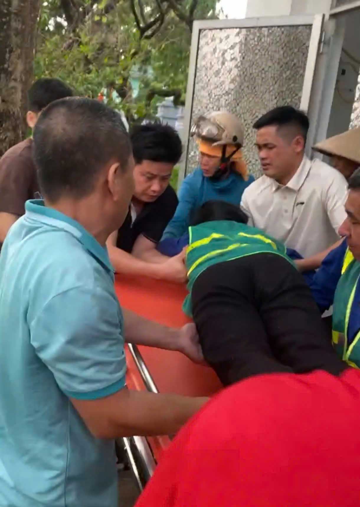 Người dân và lực lượng chức năng khẩn trương đưa nữ công nhân bị nạn đi cấp cứu sau khi cứu học sinh trong cơn dông lốc. Ảnh: CTTĐT phường Nghĩa Lộ 