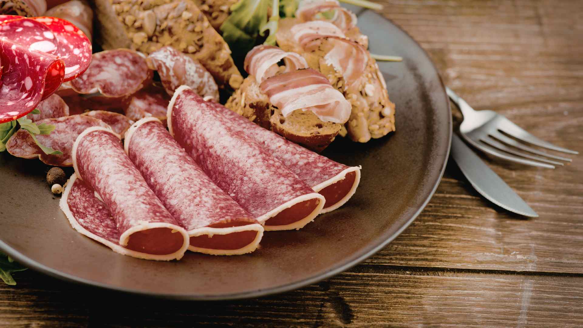 Platos familiares como salchichas, jamón o fiambres suelen contener mucho sodio, fósforo y conservantes, lo que aumenta la presión sobre el sistema de filtración renal. Foto gráfica: Hương Sơn