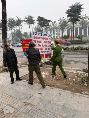 Công an phường Định Công xử lý lấn chiếm lòng đường, vỉa hè đường Phạm Tu. Ảnh: Minh Hạnh