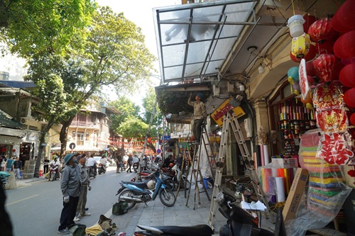 Lực lượng chức năng phường Hoàn Kiếm tháo gỡ mái che, mái vẩy lấn chiểm vỉa hè. Ảnh: Hữu Chánh