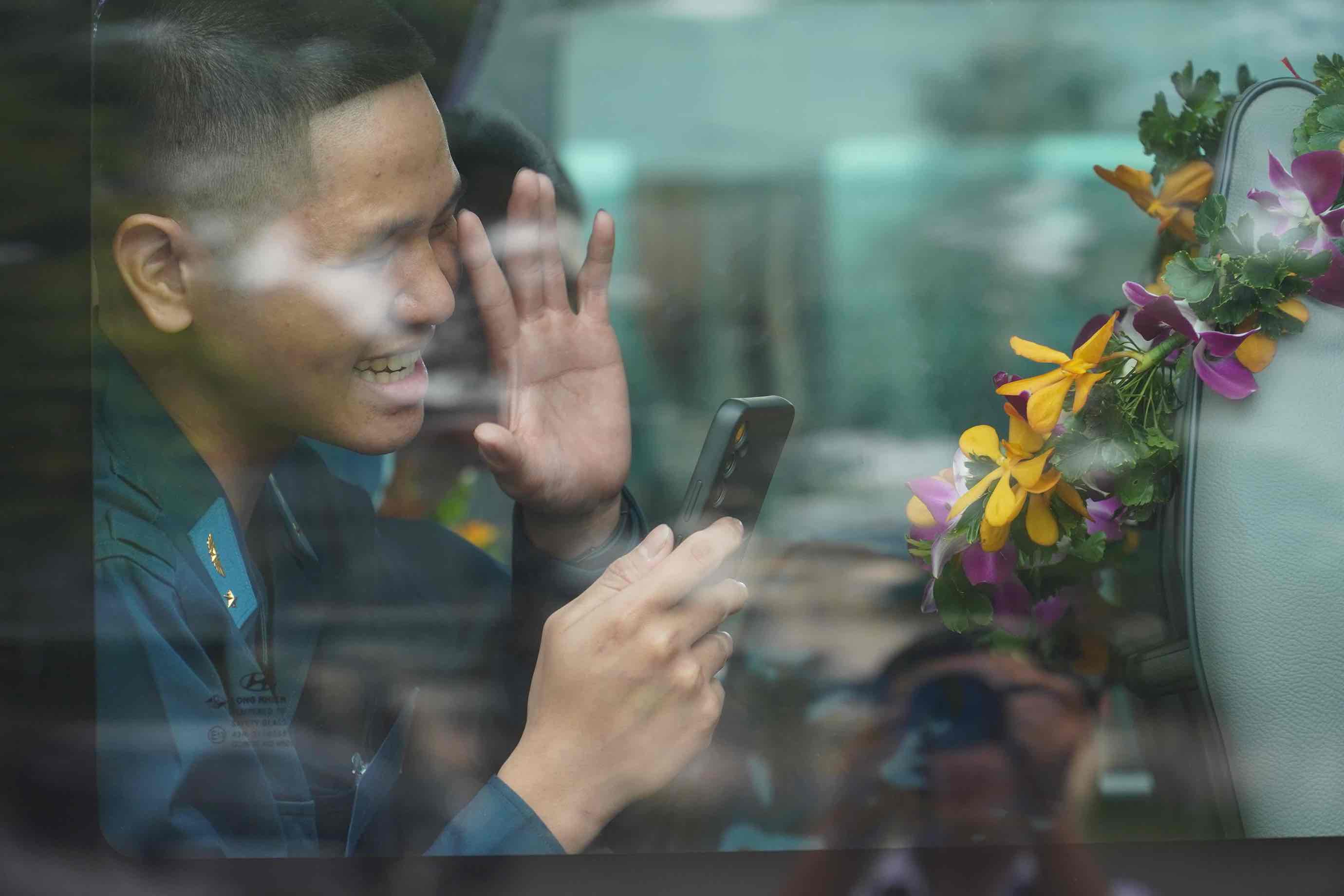 Một tân binh lên xe, chào tạm biệt người thân. Ảnh: HAC