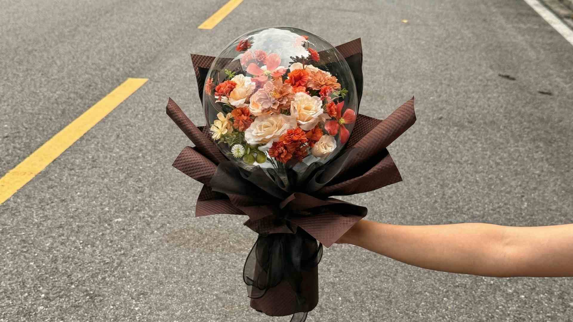 Người Hà Nội chuộng hoa lụa trong bong bóng dịp 8.3. Ảnh: NVCC