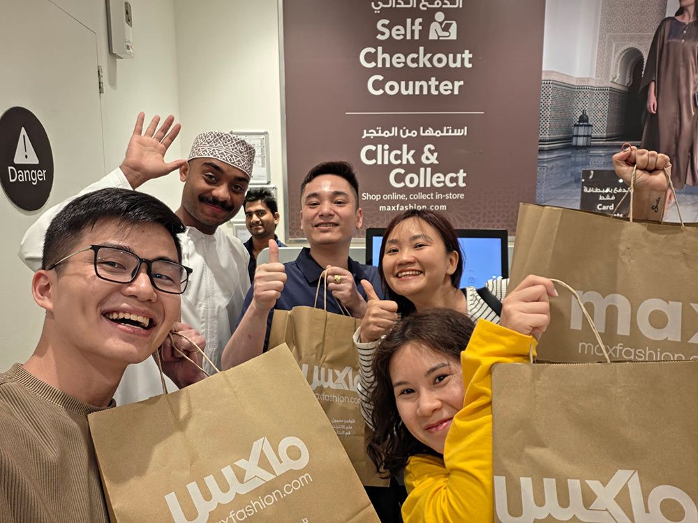 Nhân viên cửa hàng quần áo thân thiện ngỏ ý chụp ảnh cùng những du khách Việt đang mắc kẹt ở Oman. Ảnh: Đức Trịnh