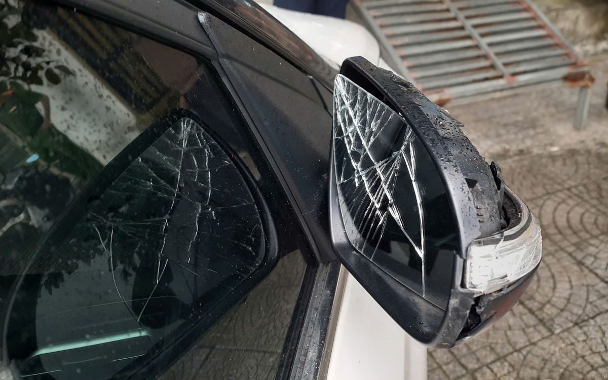 Gương chiếu hậu của một xe ô tô bị người phụ nữ đập phá, gây hư hỏng. Ảnh: H.Nguyên