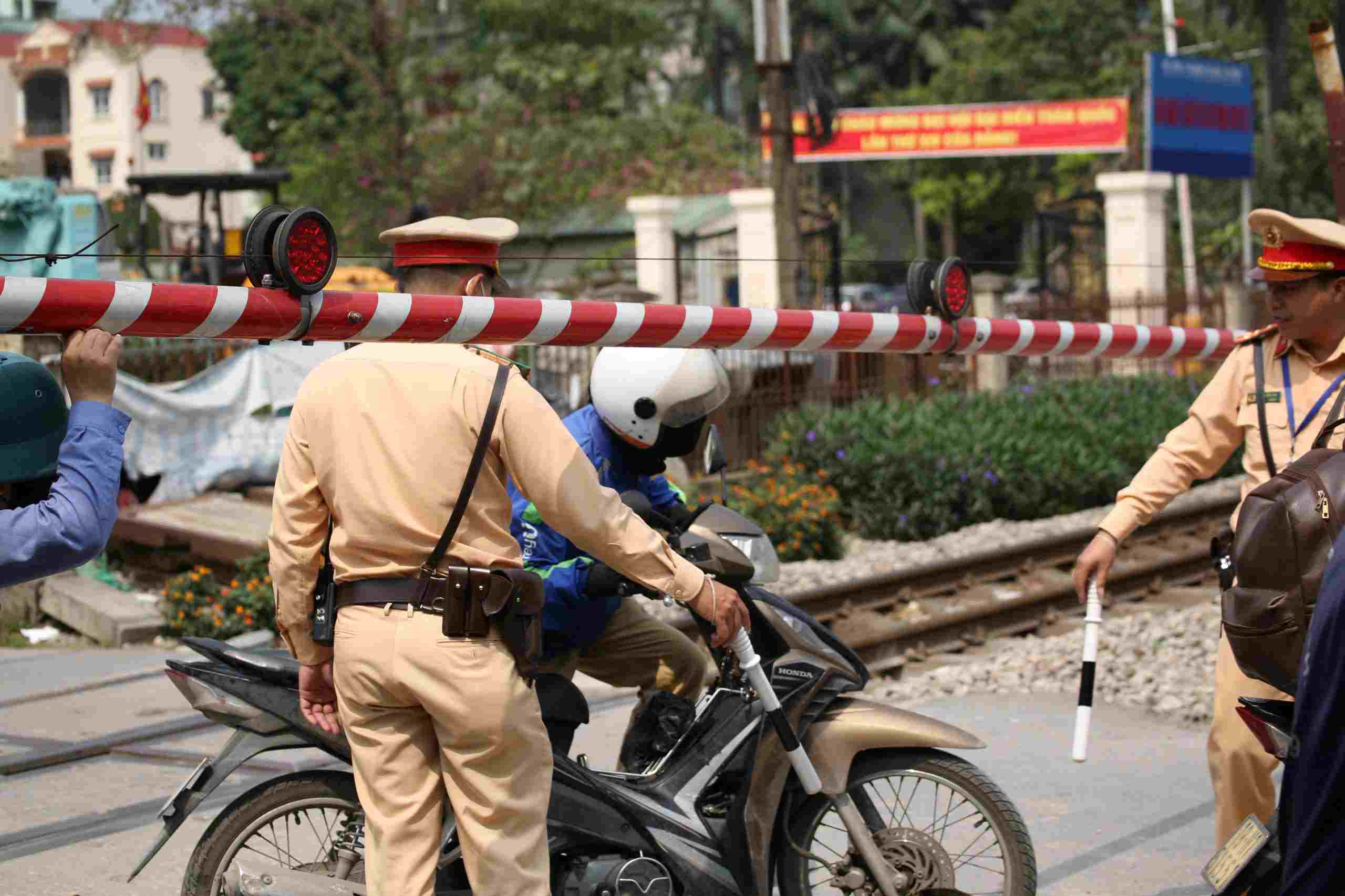Motorcyclists trapped on the railway tracks as the barriers are lowering. Photo: The Ky