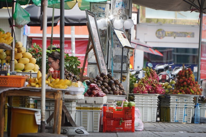 Một sạp trái cây bày bán quá vạch vôi quy định, lấn chiếm lối đi của người đi bộ. Ảnh: Thái Bảo