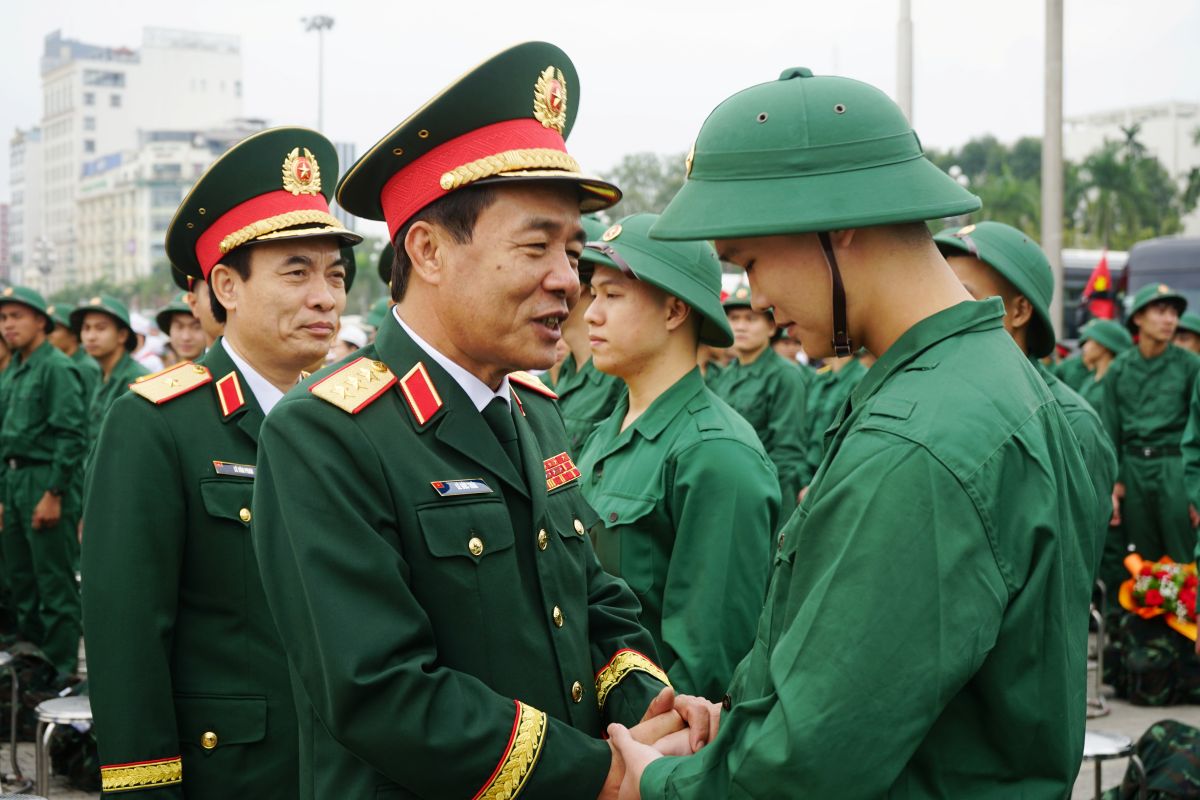 Thượng tướng Lê Đức Thái, Thứ trưởng Bộ Quốc phòng trò chuyện, động viên tân binh tại buổi lễ giao nhận quân. Ảnh: Quách Du