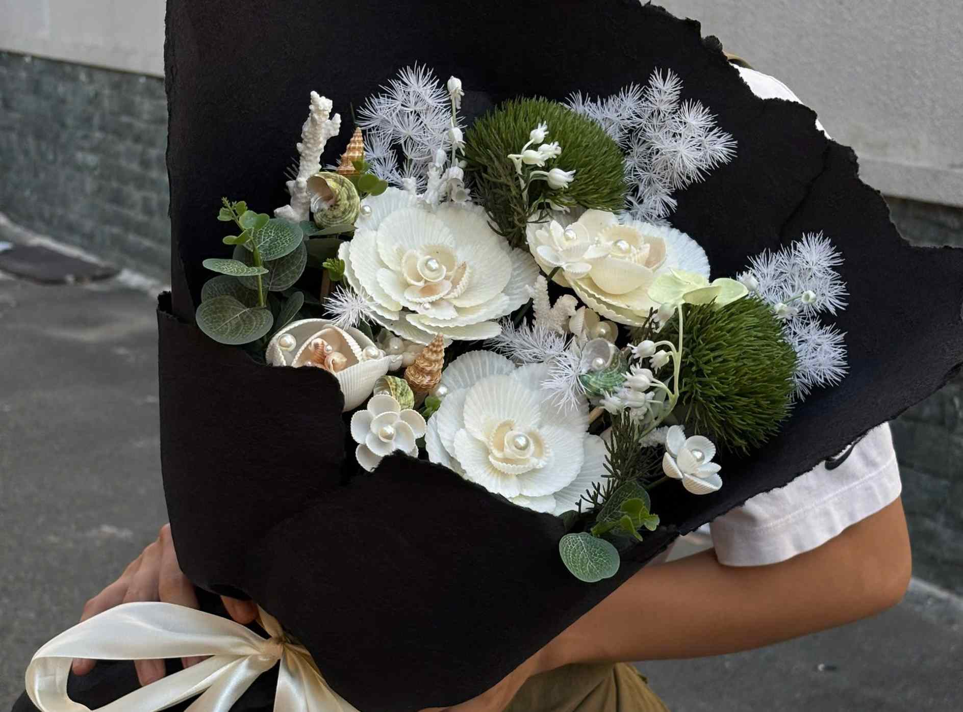 Những bó hoa được làm từ vỏ sò, vỏ ốc thủ công đang thu hút nhiều khách hàng tìm mua làm quà tặng dịp 8.3. Ảnh: NVCC