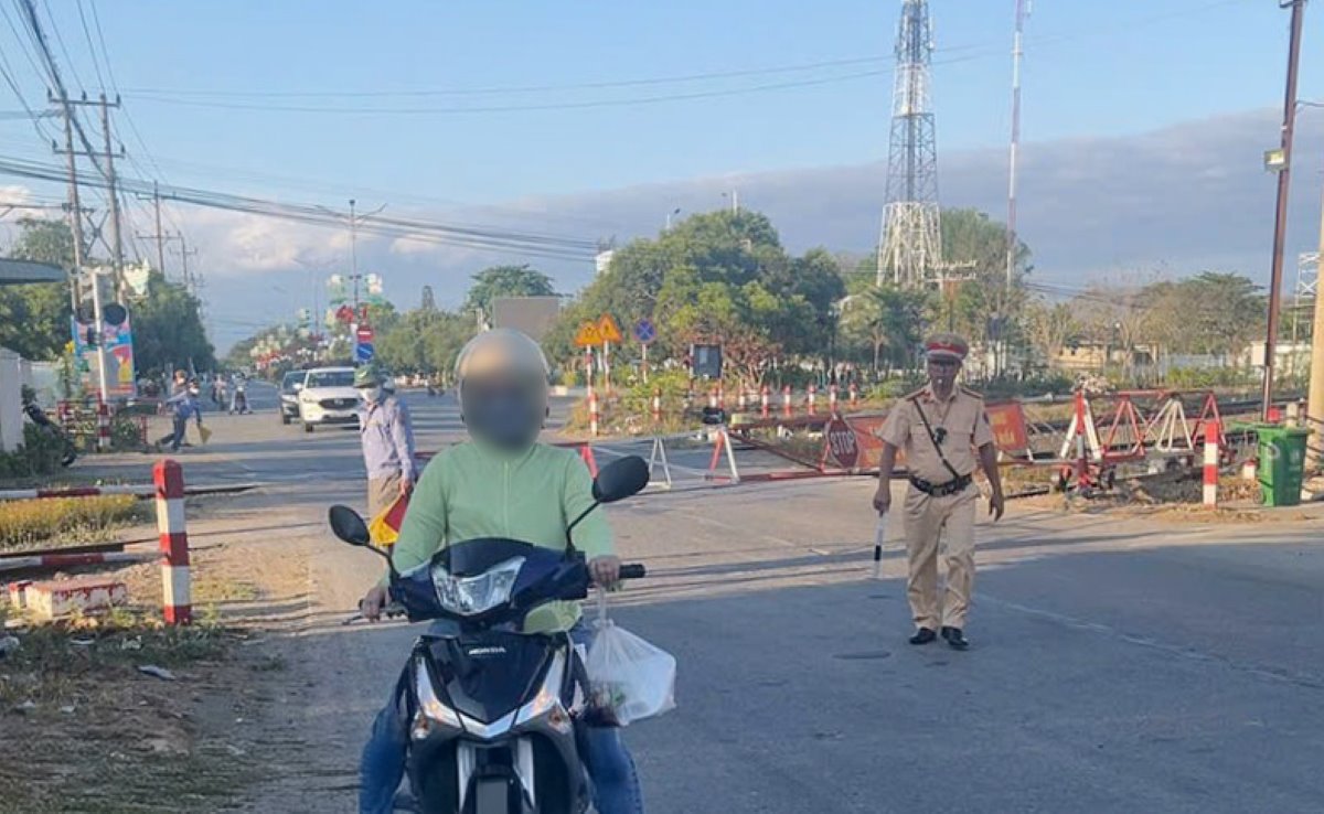 Một người đi xe máy cố tình vượt rào chắn đã bị xử phạt. Ảnh: Phạm Duy 