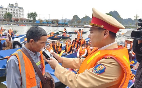 Cảnh sát lên đò kiểm tra nồng độ cồn người lái, đảm bảo an toàn ở lễ hội Chùa Hương. Ảnh: Hoàng Lam