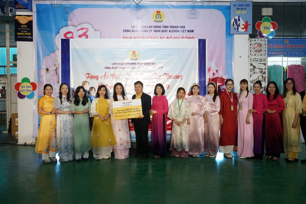 Đại diện Ngân hàng Thương mại Cổ phần Bắc Á trao áo dài cho nữ công nhân lao động tại Công ty TNHH Giày Aleron Việt Nam. Ảnh: Quách Du