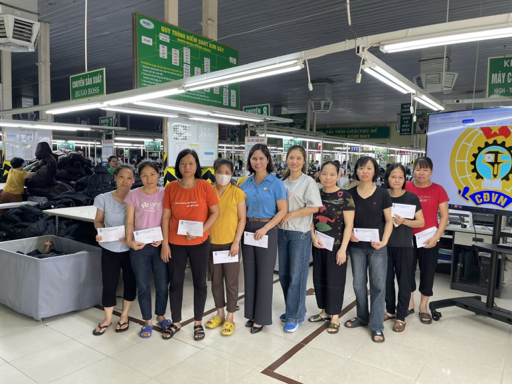 Ms. Le Thi Thu Thuy - Chairwoman of the Trade Union of Nam Dinh Textile and Garment Joint Stock Corporation (5th from the left) - presents gifts to female workers at the production workshop on the occasion of October 20, 2025. Photo: Character provided