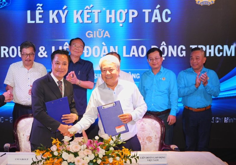 Representatives of the Ho Chi Minh City Labor Federation (third from right) and LNT 7979 Service Development Joint Stock Company (second from left) sign a memorandum of understanding on cooperation to build 30,000 social housing units for workers and laborers. Photo: Nam Duong