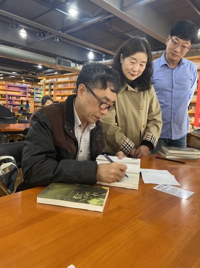 Writer Nguyen Binh Phuong autographs the book "Me and them" - Korean translation - for Korean writers on the book launch in Seoul. Photo: Character provided