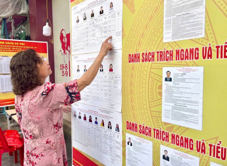 Ms. Nguyen Thu Huong (Hoan Kiem ward, Hanoi) learns about candidates for National Assembly deputies and People's Council deputies at all levels at National historical and cultural relic No. 48 Hang Ngang, Hanoi. Photo: Nguyen Phuong
