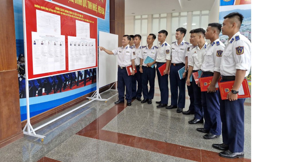 Head of Coast Guard Region 4 Command and officers and soldiers study the list and biography of National Assembly and People's Council candidates of An Giang province. Photo: Quang Vinh