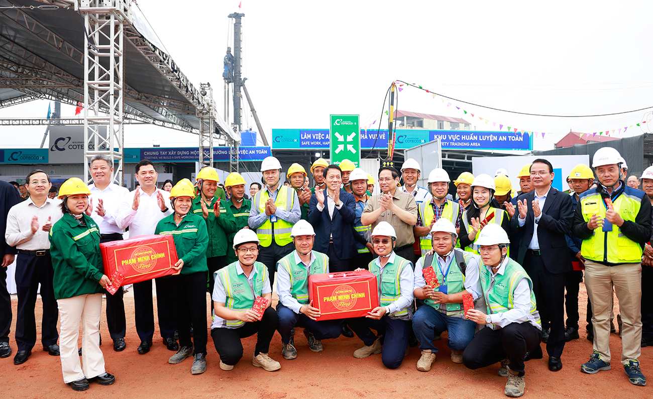 Thủ tướng Chính phủ Phạm Minh Chính và Đại tướng Lương Tam Quang - Bộ trưởng Bộ Công an tặng quà, động viên công nhân đang xây dựng trên công trường dự án sân bay Gia Bình. Ảnh: Dương Thủy  