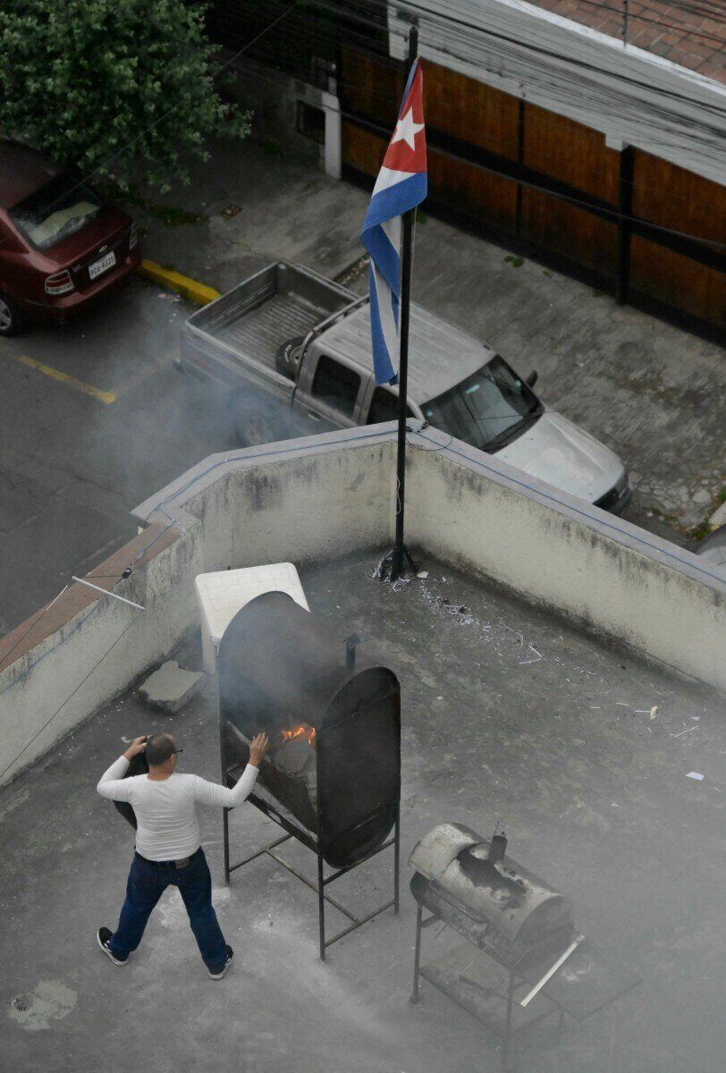Một người đàn ông đốt giấy tờ trên sân thượng của Đại sứ quán Cuba ở Quito ngày 4.3.2026. Ảnh: AFP 