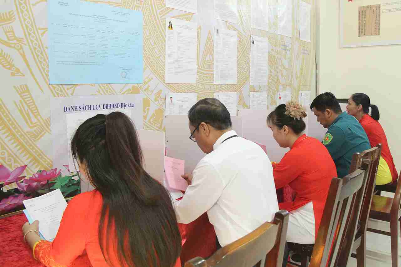 Cử tri lần lượt xuất trình thẻ cử tri, nhận phiếu bầu đại biểu Quốc hội và đại biểu HĐND các cấp, vào khu vực viết phiếu kín, sau đó tự tay bỏ phiếu vào hòm phiếu dưới sự chứng kiến của tổ bầu cử và cử tri. Ảnh: Đức Thu