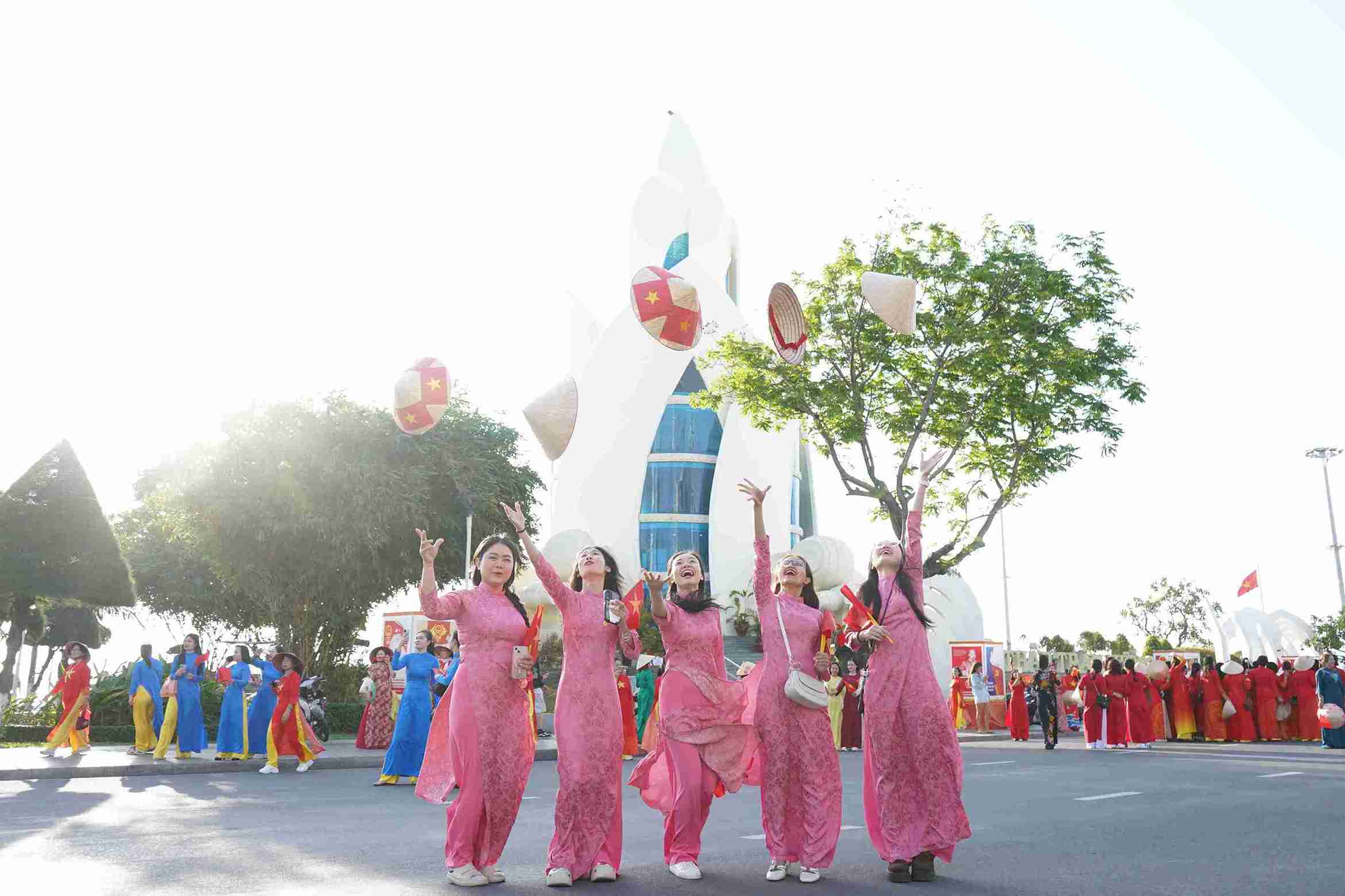 Union members and workers participate in the ao dai parade on the coastal road of Nha Trang. Photo: Huu Long