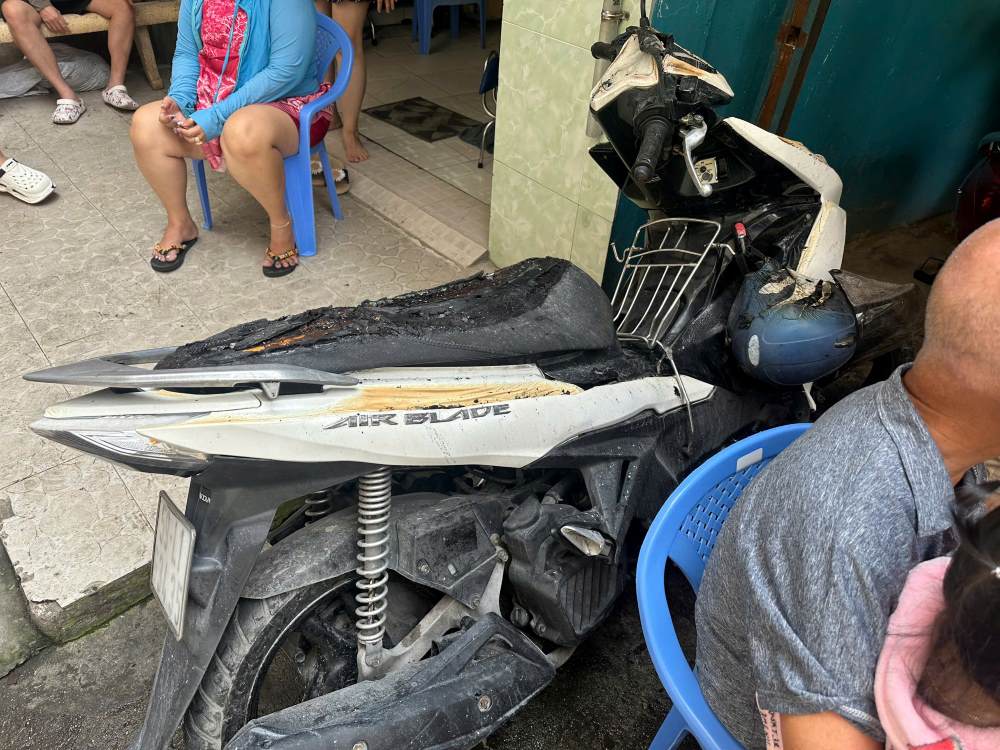 Một chiếc xe máy được người dân kịp thời đưa ra khỏi đám cháy, phần yên đã bị ngọn lửa thiêu rụi. Ảnh: Hoàng Chinh