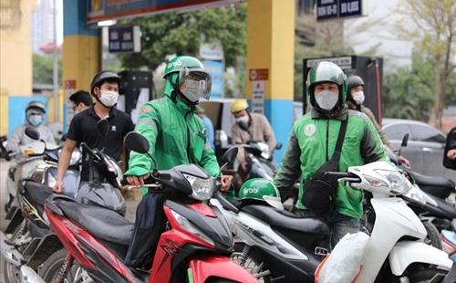 Les prix de l'essence et du pétrole fluctuent, les entreprises de transport et les chauffeurs technologiques réagissent de manière flexible. Photo: Ngo Cuong