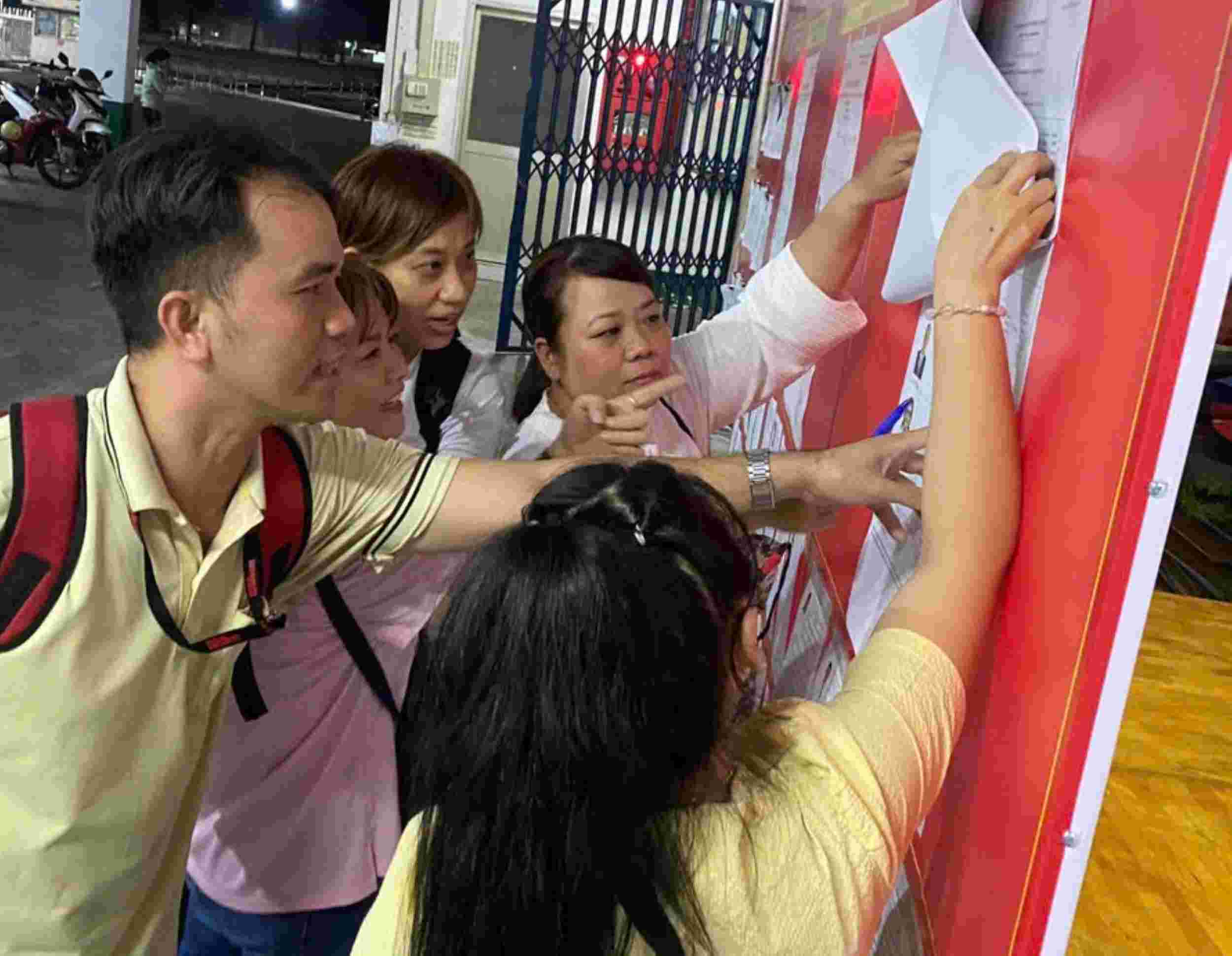 Workers of PouYuen Vietnam Co., Ltd. view the list of candidates for National Assembly and People's Council deputies at all levels. Photo: Duc Long