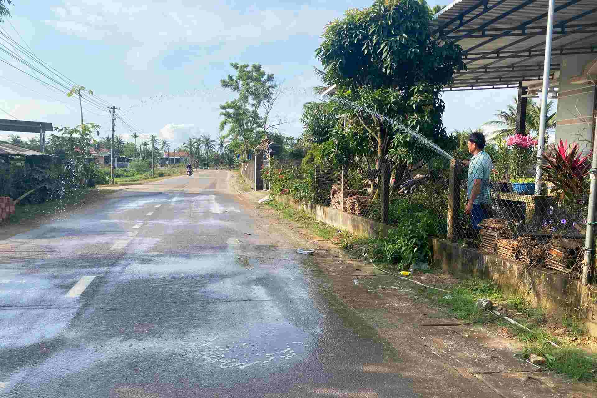 People in Thuan Nhut village (Binh Hiep commune) proactively water on DT638 route to reduce dust from soil trucks serving the project. Photo: Hoai Phuong
