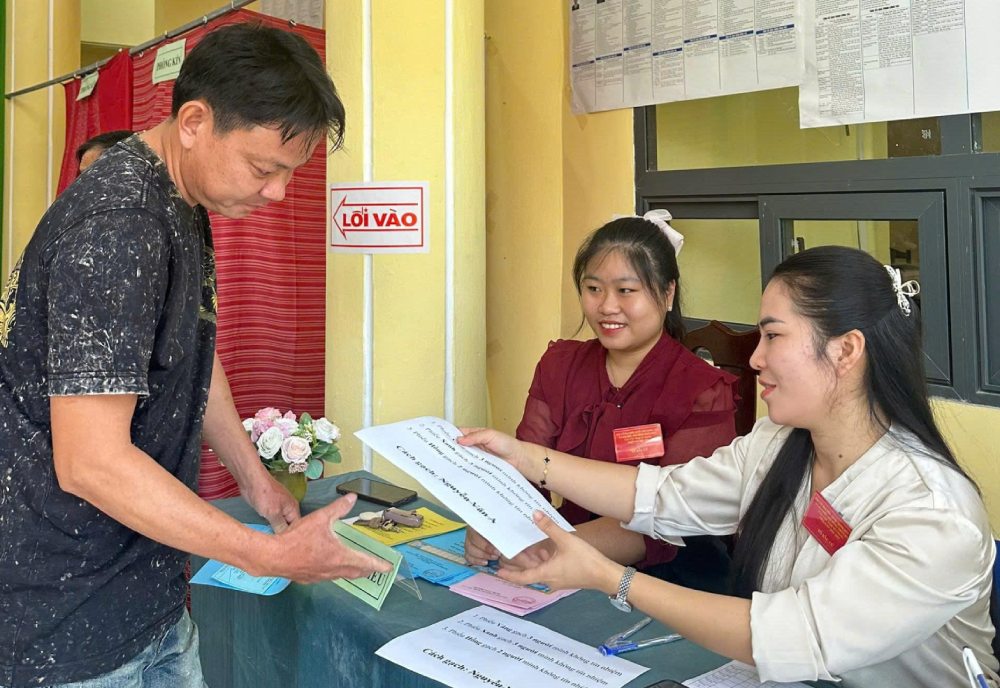 Hướng dẫn cử tri bỏ phiếu đúng quy định. Ảnh: Văn Vũ