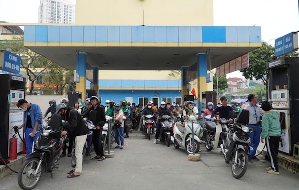 People line up to wait for their turn to refuel, after gasoline prices were adjusted up. Photo: Van Trang