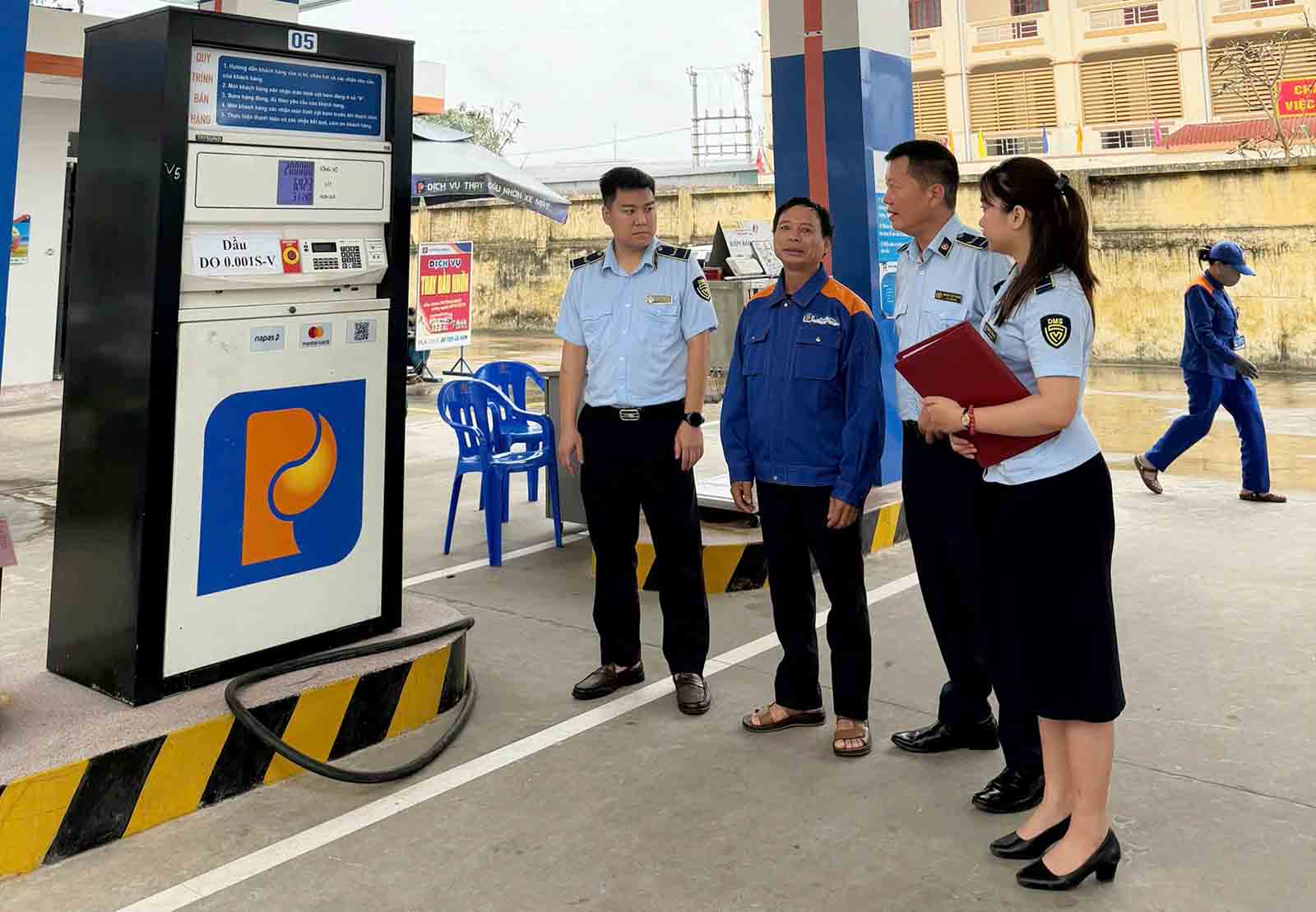 Cán bộ quản lý thị trường Hà Tĩnh tuyên truyền về việc chấp hành quy định bán xăng dầu, không được găm hàng. Ảnh: Trần Tuấn