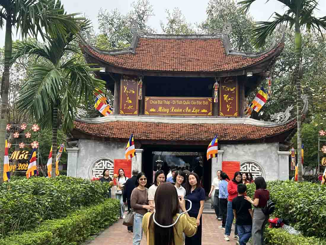 Du khách chụp hình lưu niệm trước lối vào chùa.