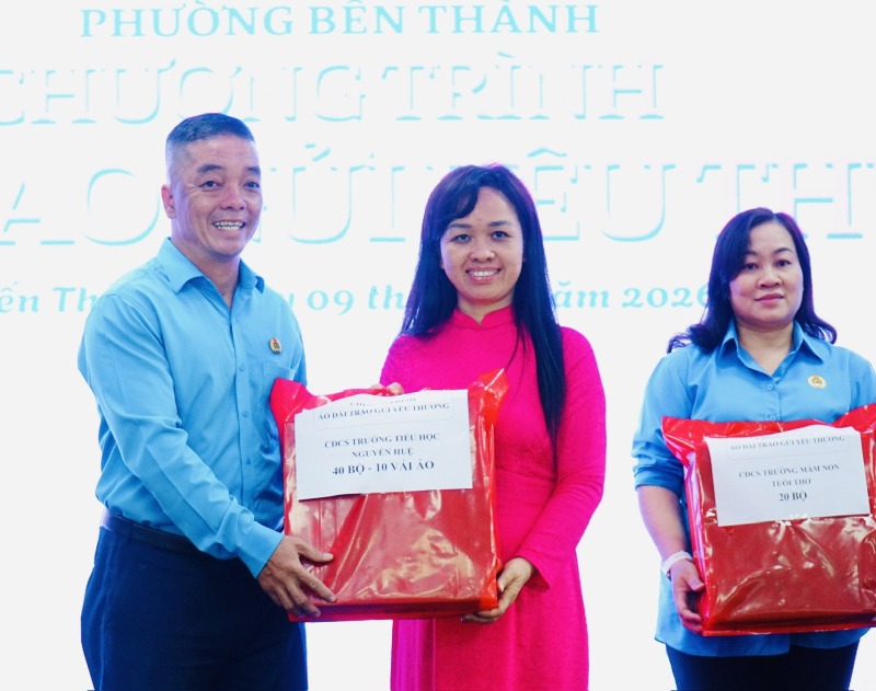 Mr. Huynh Vinh Lam - Chairman of Ben Thanh Ward Trade Union - receives ao dai awarded by grassroots trade unions to give to union members and workers in difficult circumstances. Photo: Duc Long