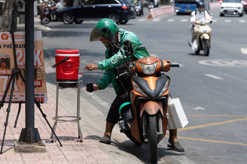Điểm dừng chân giản dị với ghế nhỏ và bình nước miễn phí trên đường Nguyễn Hữu Cảnh thu hút người chờ xe buýt.