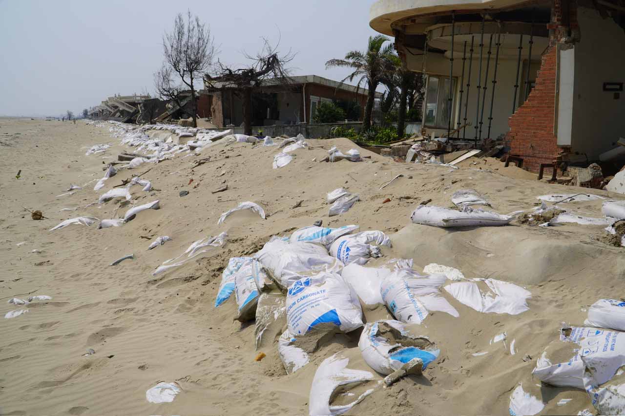 Nhiều bao tải cát được gia cố nay đã rách nát, sóng đánh dạt ra nhiều hướng. Ảnh: Trần Tuấn