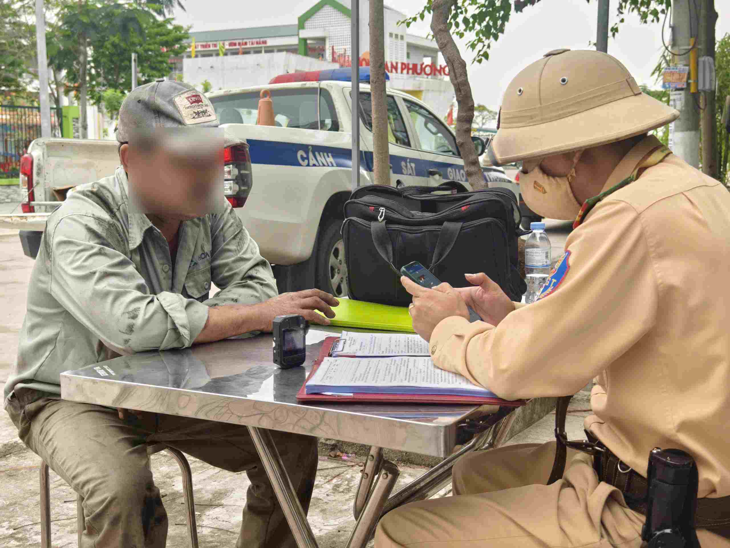 Lực lượng chức năng lập biên bản xử lý đồng thời tịch thu phương tiện vi phạm, xử lý theo quy định. Ảnh: Tiến Ngô