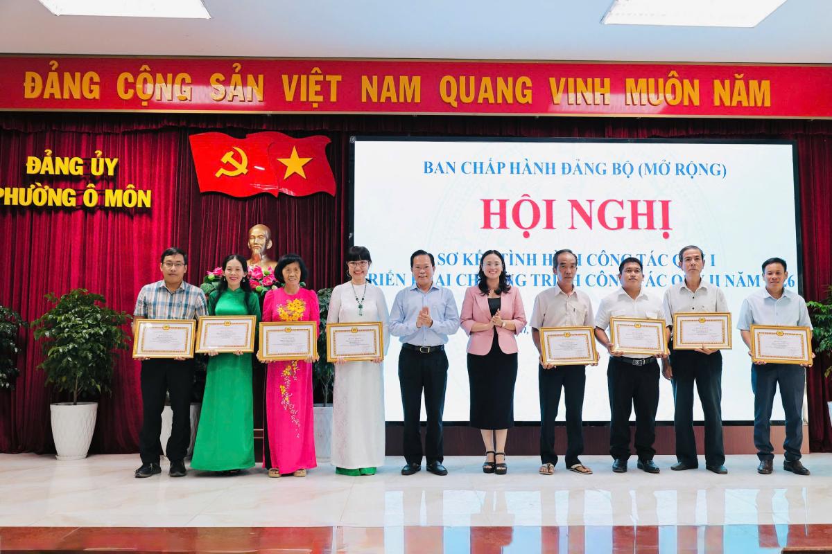 La presidenta de la Federación Laboral de la ciudad de Can Tho, Le Thi Suong Mai, y el secretario del Comité del Partido del barrio de O Mon, Chau Viet Tha, recompensan a los miembros del partido "que completaron excelentemente sus tareas" típicos durante 5 años consecutivos. Foto: Huong Nha