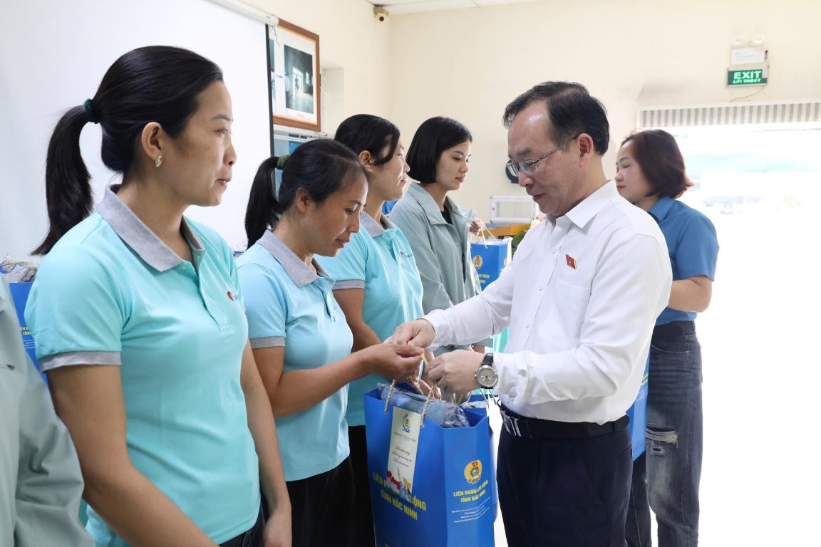 Deputy Head of the National Assembly Delegation of Bac Ninh province Tran Van Tuan presents gifts to workers in difficult circumstances. Photo: Quyet Chien