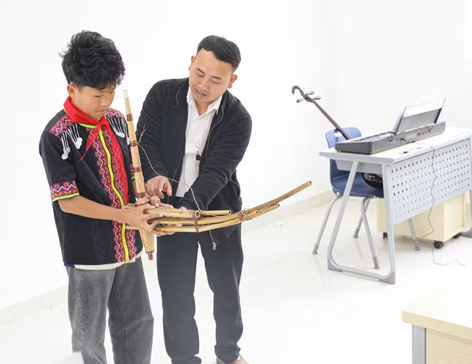 Giáo viên hướng dẫn học sinh sử dụng nhạc cụ dân tộc. Ảnh: Phan Quân/TTXVN