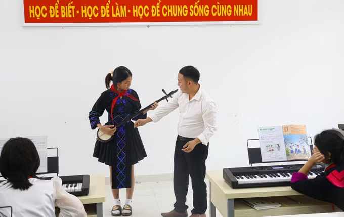 Teachers guide students to use folk musical instruments. Photo: Phan Quan/VNA